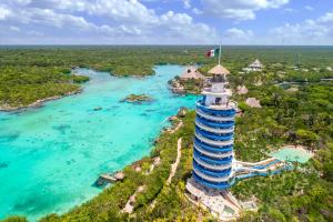 普拉亚卡门Hotel Xcaret Mexico All Parks All Fun Inclusive的海洋旁灯塔的空中景观