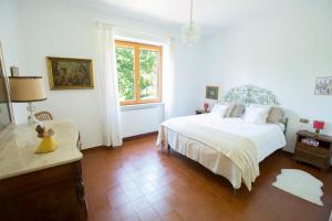 博比奥La Casa del Bosco - Villa with panoramic view of Bobbio and Val Trebbia valley的白色的卧室设有床和窗户