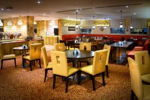 多哈金色海滨酒店的一间带桌椅的餐厅和一间酒吧