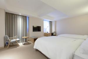 首尔东大门阿酷酒店的一间卧室配有一张床、一张书桌和一台电视。