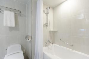 首尔东大门阿酷酒店的带浴缸、卫生间和淋浴的浴室。