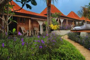 乌鲁瓦图瑜伽寻找者巴厘岛度假村的前面有紫色花的房屋