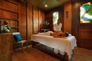 乌鲁瓦图瑜伽寻找者巴厘岛度假村的女人躺在与男人同居的房间里的床上