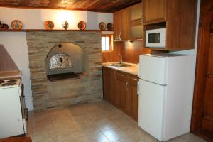 RebrevtsiLazarovata House的厨房配有砖炉和白色冰箱