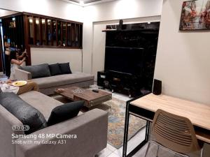 卡拉奇2 beds apartment banglow facing的客厅配有两张沙发和一台电视机