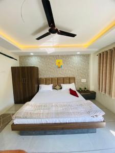 MaheshwarStayMore Premium Rooms and AC dorm的一间卧室配有一张带吊扇的床