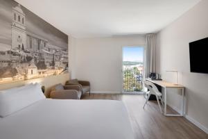 萨尔特B&B HOTEL Girona 3的配有一张床和一张书桌的酒店客房