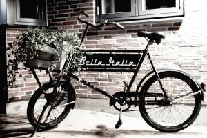 森讷堡贝拉意大利酒店的停放在砖砌建筑旁的自行车,有篮子