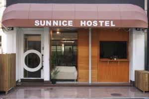 大阪南船场阳光青年旅馆Sunnice hostel的一座太阳升起的医院,在建筑物前方有标志