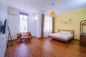 顺化Mô Tê Homestay 2 gần Chợ Đông Ba, Cung Đình Hoàng Thành Huế的卧室配有一张床和一张桌子及椅子