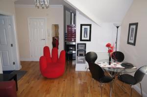 布莱克浦南海滩公寓的客厅配有红色椅子和桌子
