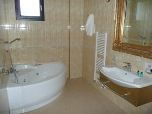切萨雷奥港Hotel Riva Del Sole的带浴缸、水槽和镜子的浴室