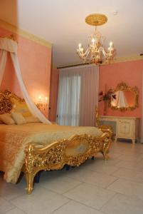 切萨雷奥港Hotel Riva Del Sole的一间卧室配有一张带吊灯的金色床