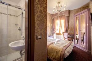 威尼斯多姆斯卡瓦尼斯酒店的一间卧室配有床和水槽,还有一间浴室