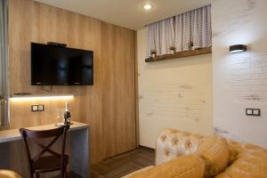 基希讷乌考米尔佛酒店的客厅配有沙发和墙上的电视