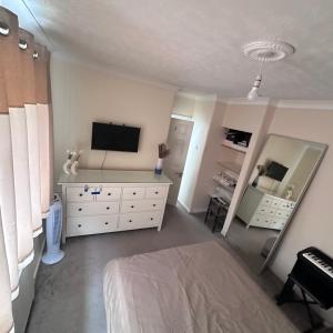 博勒姆伍德Lovely 3 bedroom house in Borehamwood .的一间卧室配有一张床和一台平面电视