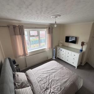 博勒姆伍德Lovely 3 bedroom house in Borehamwood .的一间卧室配有一张床、一台电视和一个梳妆台