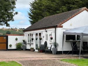 伍尔弗汉普顿Shropshire Guesthouse的白色的房子前面设有桌椅