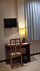 塞哥维亚唐费利佩酒店的一张桌子、椅子和墙上的电视