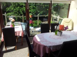 塔维斯托克Kingfisher Cottage的用餐室配有桌椅和鲜花