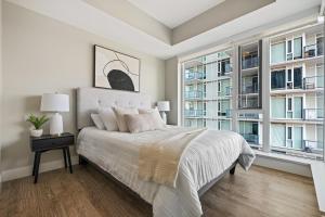 卡尔加里Modern Suite Calgary Downtown 5 min walk Stampede的一间卧室设有一张大床和大窗户