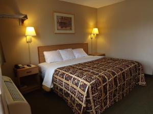基尔戈吉尔戈行政酒店的酒店客房,配有一张床和两盏灯