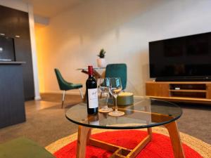 墨尔本Ideal Quiet 1BR Prahran Apt Near Cafes Transport的玻璃桌,带一瓶葡萄酒和两杯酒