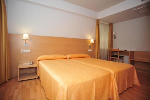 圣地亚哥－德孔波斯特拉温莎酒店的一间卧室配有一张带橙色床罩的大床