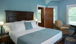 Green LakeGreenway House Bed and Breakfast的蓝色卧室配有一张大床和椅子