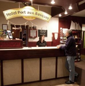 钱纳尔-巴斯克港巴斯克港口酒店的两人站在酒店港口的巴斯克柜台