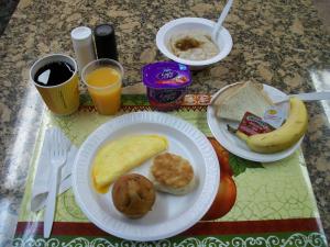 威诺纳威诺娜戴斯酒店的一张桌子,上面放着两盘早餐食品和橙汁