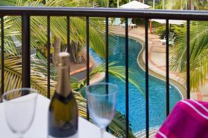 黄金海岸蓝水公寓酒店的游泳池畔的桌子上坐着一瓶葡萄酒