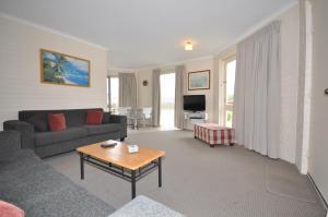 梅林布拉金沙假日公寓式酒店的客厅配有沙发和桌子