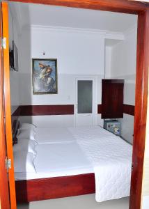 迪石Guest House 36 (2)的一间卧室配有一张带白色床单的大床