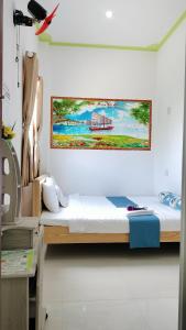 潘切Homestay Châu Triều - Phan Thiết的一间卧室设有两张床,墙上挂着一幅画