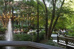 亚特兰大Crowne Plaza Atlanta Perimeter at Ravinia, an IHG Hotel的公园里的喷泉,人们坐在长椅上