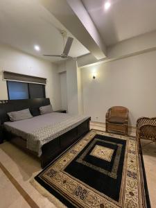 伊斯兰堡The Comfort Hub, 2 Bedroom apartment, Islamabad的一间卧室配有一张床、一把椅子和地毯