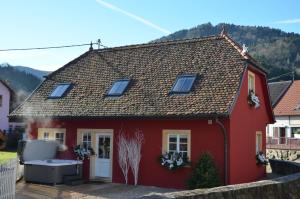 瑟温Doller Villa 4 stars Hot Tub Mountain Ski Ballon d'Alsace的前面有一座红房子,上面有热水浴缸