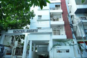 海得拉巴GAYATHRI HEIGHTS SERVICED APARTMENTS & APARTMENT HOTEL In HYDERABAD的前面有标志的白色建筑