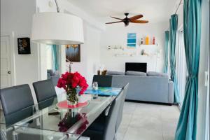 Long Bay HillsModern villas at Grace Bay, Turks and Caicos Islands的客厅配有桌子和沙发