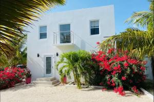 Long Bay HillsModern villas at Grace Bay, Turks and Caicos Islands的前面有鲜花的白色房子