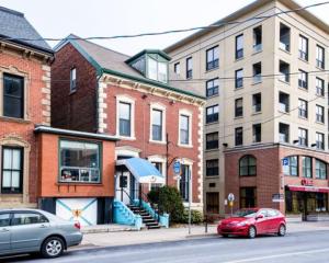 哈利法克斯HI Halifax - Hostel的2辆汽车停在城市街道上,街道上有许多建筑