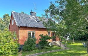 韦克舍Cozy Home In Växjö With Kitchen的一座带金属屋顶的红砖房子