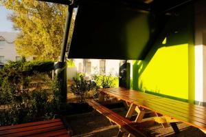 塞普特梅斯·莱瓦隆勒芒酒店的绿色墙壁旁的木凳