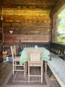 雷丹尼茨恩Cozy Log Cabin near Faaker See的小屋门廊上的桌椅