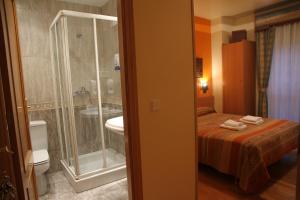 潘普洛纳阿瑟拉旅馆的配有床、淋浴和盥洗盆的浴室