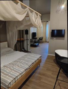 法诺"Da Manu Loft" Centro Storico的一间卧室设有一张天蓬床和客厅