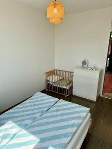 巴塞尔Rooftop Loft, 170sq, 1min from Main Station的一间小卧室,配有婴儿床和梳妆台