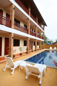 拉迈华泰楼酒店的一座带游泳池和椅子的度假村和一座建筑