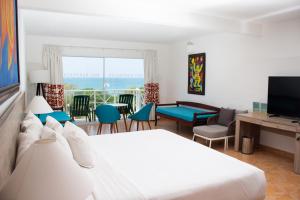 普拉亚布兰卡Grand Decameron Panama, A Trademark All Inclusive Resort的一间卧室设有一张床和一间客厅。